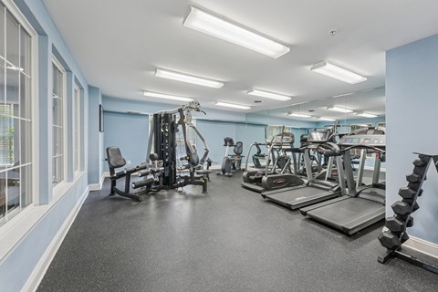 A spacious gym with a variety of equipment including treadmills, weights, and exercise machines.